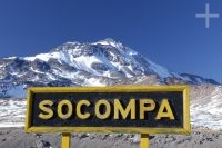 Sign indicating the Socompa train stop (Argentina-Chile border), in back the Socompa volcano, province of Salta, Argentina